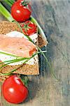 Toast the bread from grain and salmon on a wooden table.