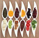 Healthy super food selection in white  porcelain dishes over papyrus background.