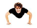 Healthy young guy doing push-ups exercise against white background