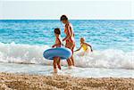 Family (mother with two children) have the water-based recreation on white Egremni beach (Ionian sea, Lefkada, Greece)