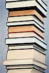 High stack of books over a gray background