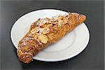 Almond Croissant French Pastry on White Plate