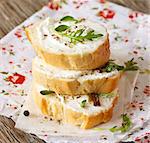 Fresh cream cheese spread with spices and herbs on a crispy baguette for breakfast.