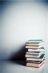 Stack of red, green and black books on white reflective surface