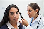 Patients ear being checked by doctor using otoscope in hospital