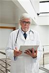 Doctor looking at patient files in hospital corridor