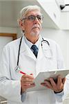 Doctor holding patient file and looking up in hospital corridor