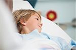 Child lying in hospital bed smiling