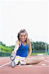 Woman stretching legs on running track