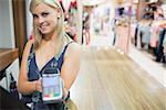 Woman with credit card machine in clothing store