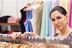 Woman standing by clothes rack in boutique