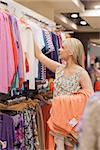 Woman taking clothes off the clothes rack