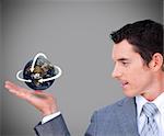 Hovering globe in Businessman's hand on grey background