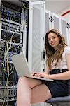 Woman with laptop doing data storage in data center