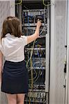 Woman fixing server wires in data center