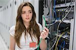 Woman holding wire at the servers in data center