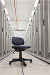 Chair in empty row of servers in data center