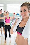 Woman with water and towel in aerobics class