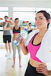 Woman drinking water at aerobics class in fitness studio