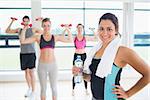 Woman at front of aerobics class in fitness studio