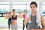 Man taking break from aerobics class with water and towel