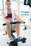 Young woman on the row machine in fitness studio