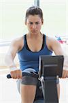 Focused woman at the rowing machine in the gym
