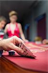 Man lifting poker hand in casino