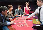 Four people playing poker in casino