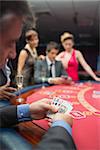 Man looking at his cards in poker game at casino