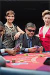 Man in sunglasses smiling at poker table in casino