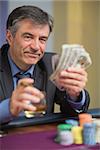 Man holding money and smiling in casino