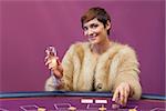 Woman with champagne at poker table in casino