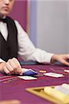 Dealer distributing cards in a casino while sitting at table