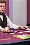 Dealer stacking cards at table of a casino while concentrating