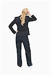Standing businesswoman thinking while holding her hand on the head backwards