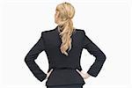 Reversed businesswoman standing with her hands on the hip while thinking