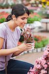 Woman raising a flower while smelling on a flower