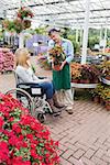 Woman in wheelchair looking at the plant in garden centre