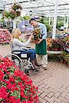 Woman in wheelchair buying a flower in garden centre