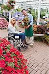 Smiling woman in wheelchair buying a flower in garden centre