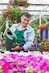 Man watering plants in garden center