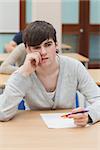 Student sitting at table while thinking