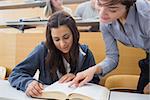 Teacher and student looking at a book at the lecture hall