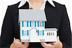 Businesswoman holding a model house against white background