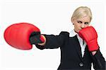 Blonde businesswoman with red gloves fighting against white background