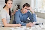 Couple getting stressed over bills in kitchen