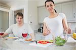 Smiling couple having lunch in kitchen at home