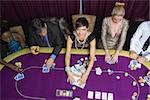 Woman taking the pot at poker game in casino