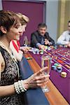 Woman holding glass of chanpagne at roulette in casino